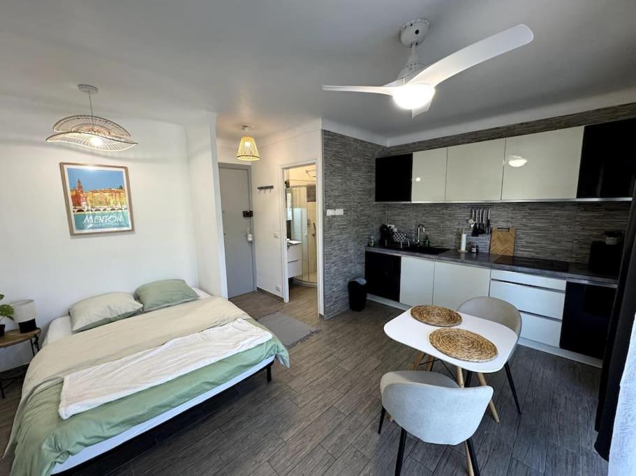 une chambre avec un lit et une table et une cuisine dans l'établissement Studio Cosy - Bord de mer, à Menton