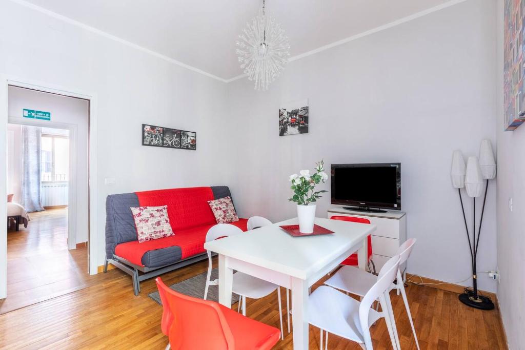 salon z białym stołem i czerwoną kanapą w obiekcie Florje House w Rzymie