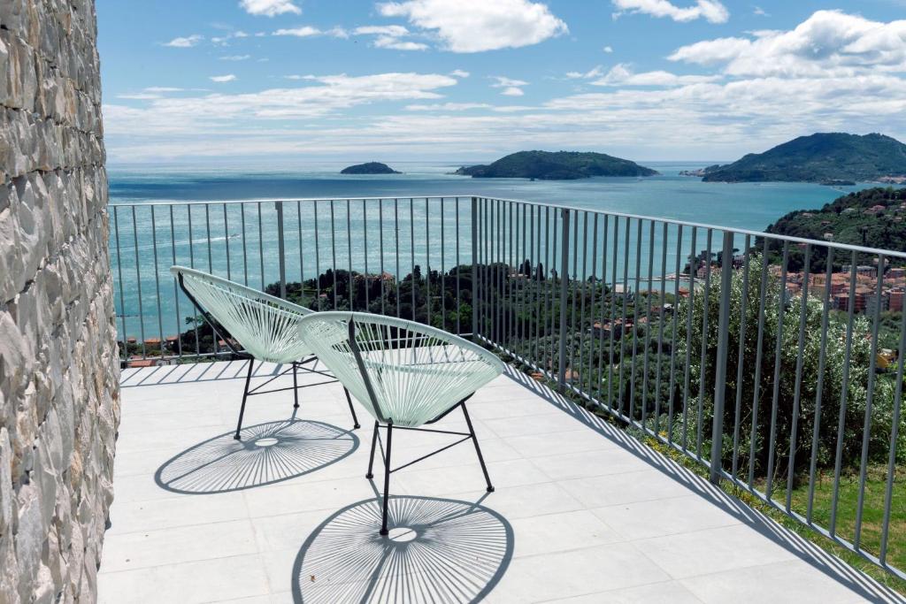 a chair on a balcony with a view of the ocean at "Torretta House", inside a Private Park, shared Pool, Tennis, AC, parking next home and parking in Lerici! in Lerici