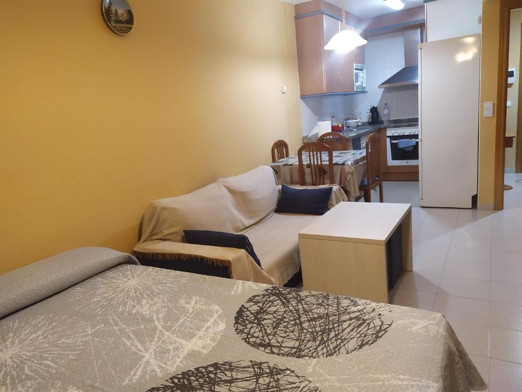 Una sala de estar con un sofá y una cocina. en TU CASA EN MEQUINENZA CON WIFI, en Mequinenza