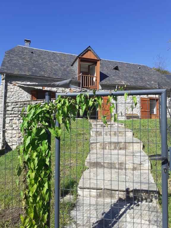 a fence in front of a house with vines at Gîte Pause du Berger in Saint-Pastous