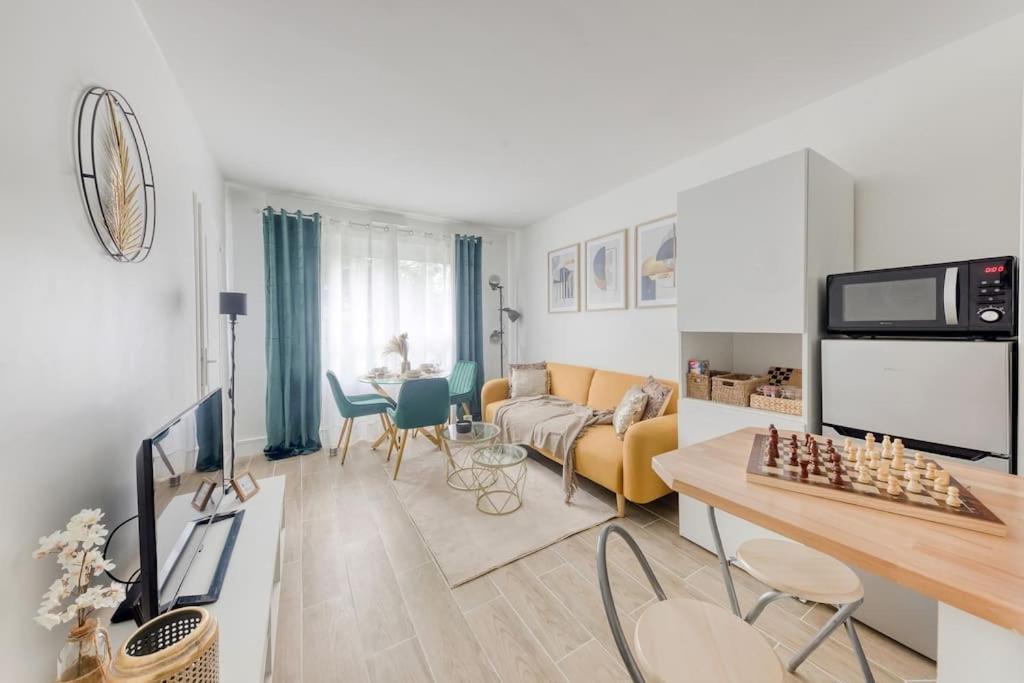 un salon avec un canapé et une table dans l'établissement Charmant T2 proche stade de France et RER B, à Aubervilliers