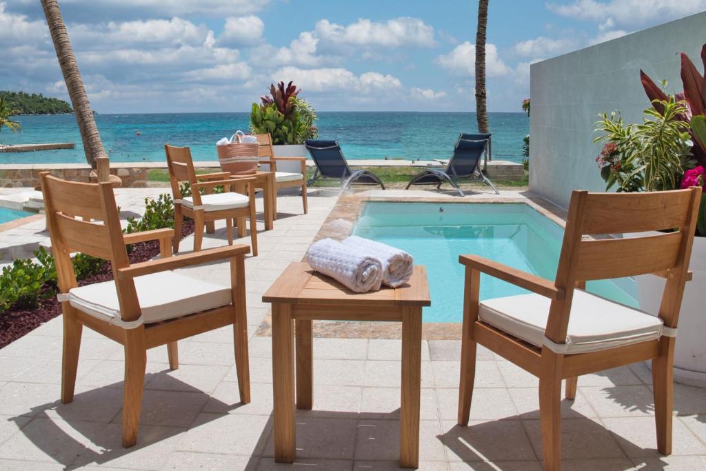 a group of chairs and a pool with the ocean at JW Marriott St Maarten Beach Resort & Spa in Dawn Beach