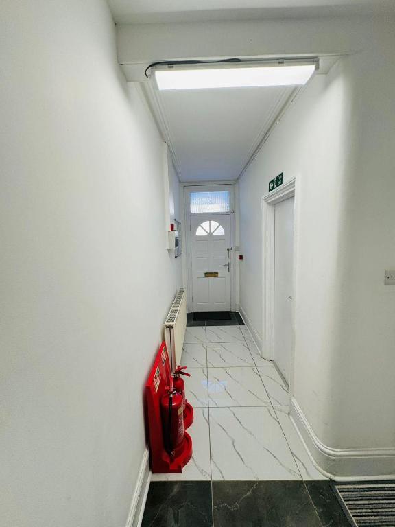 a hallway with a red object on the floor at Room for stay with shared facilities in Uxbridge