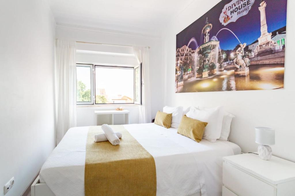 1 dormitorio blanco con 1 cama y una gran pintura en la pared en Divine House of Graça, en Lisboa
