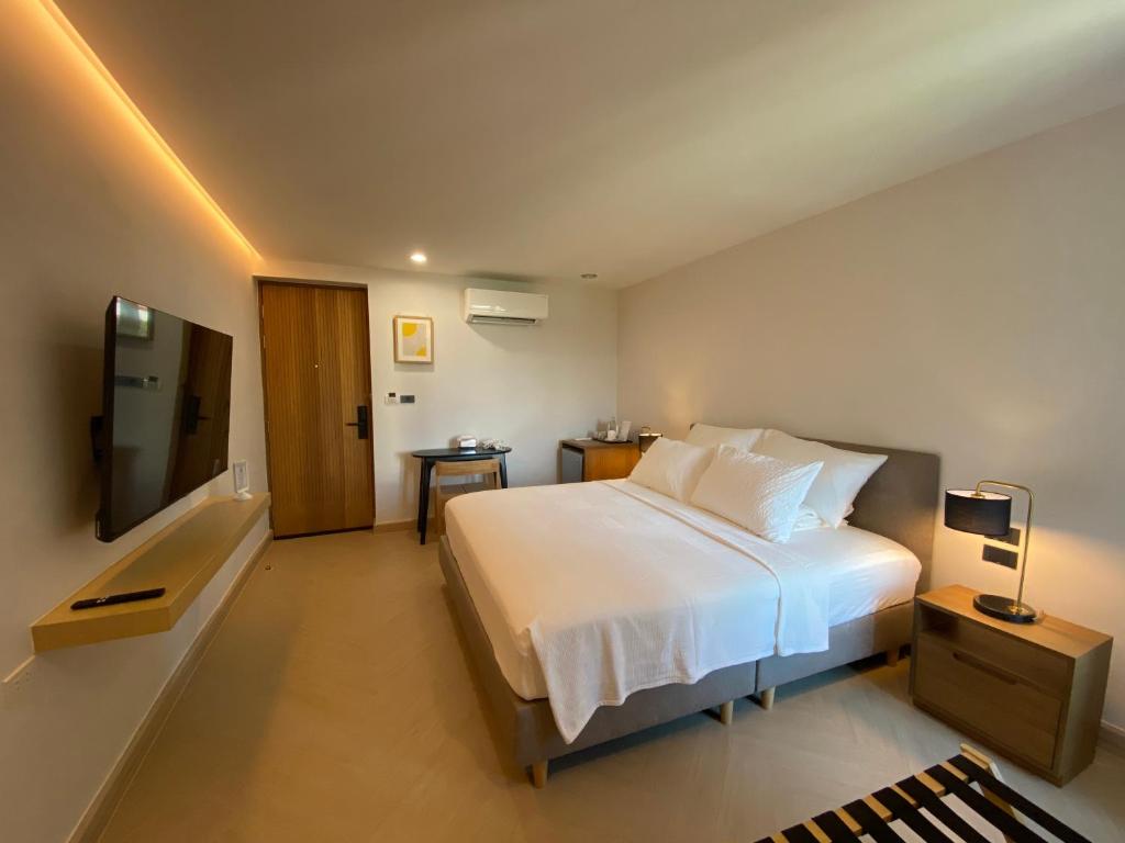 a bedroom with a white bed and a television at THE CELESTRAIL - Apartment - Check-In by Appointment Only - Non-hotel - Onnut BTS in Bangkok