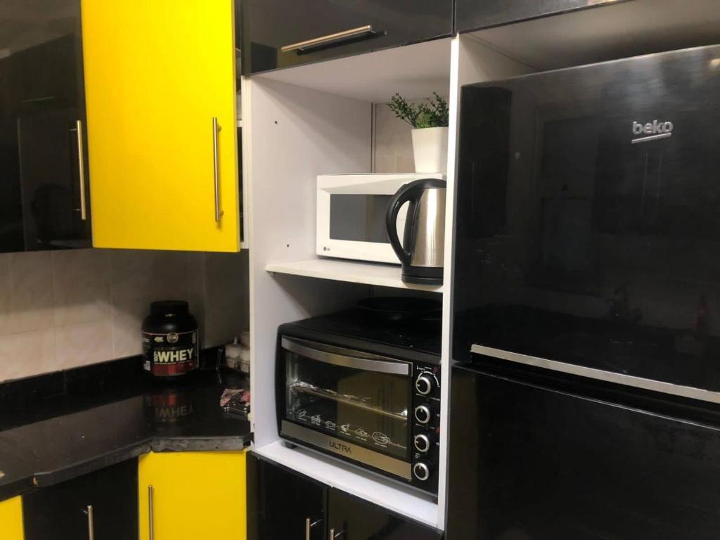 a small kitchen with a microwave and a stove at Chilling home in Madinaty