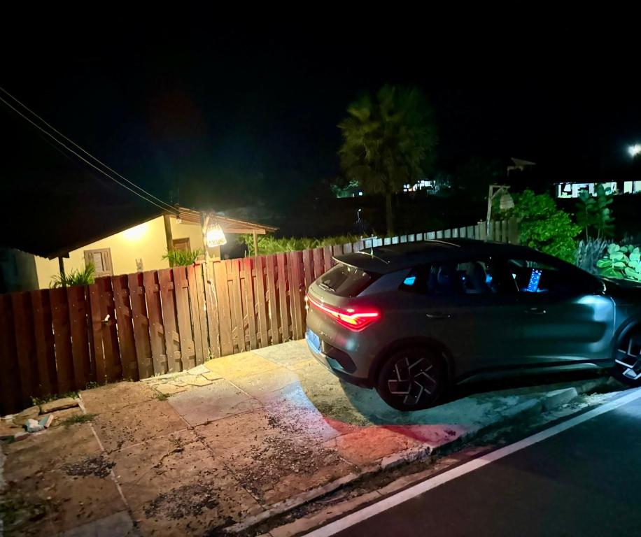 a car parked in front of a fence at night at Casa SRBG - 2 Quartos com Ar - 150m da Praia in Barra Grande