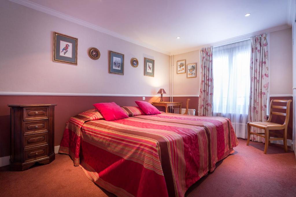 sypialnia z dużym łóżkiem z różową pościelą w obiekcie Hotel des Arts - Cite Bergere w Paryżu