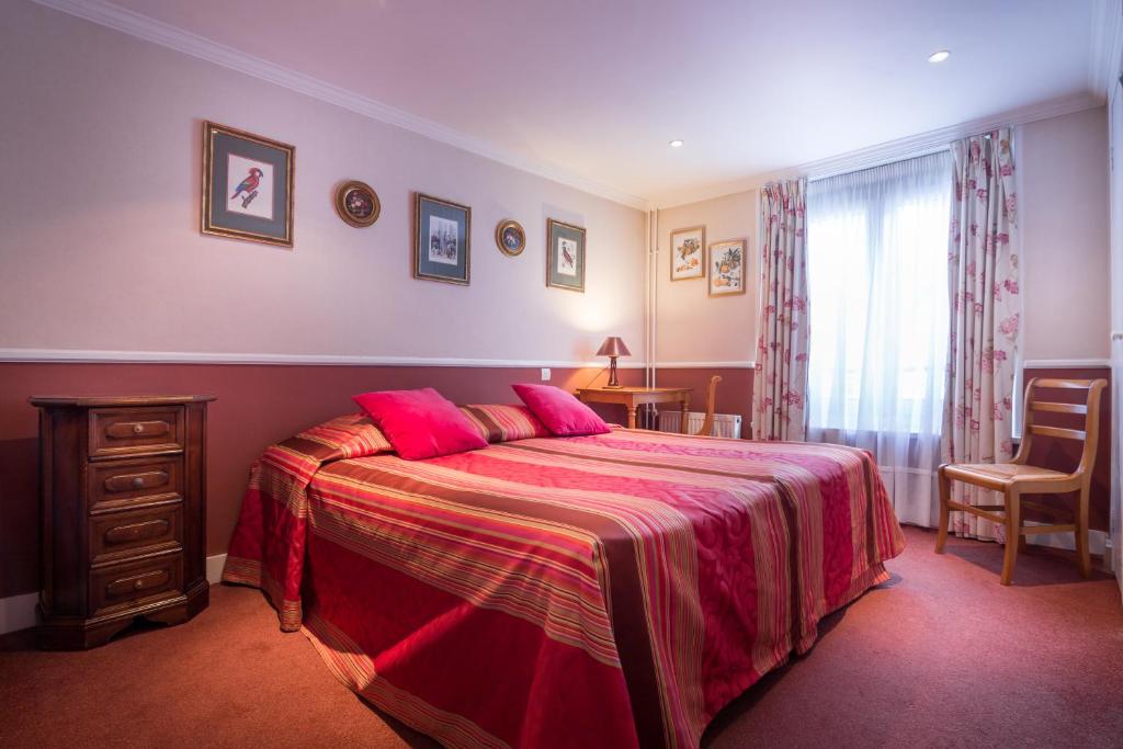 a bedroom with a large bed with pink sheets at Hotel des Arts - Cite Bergere in Paris