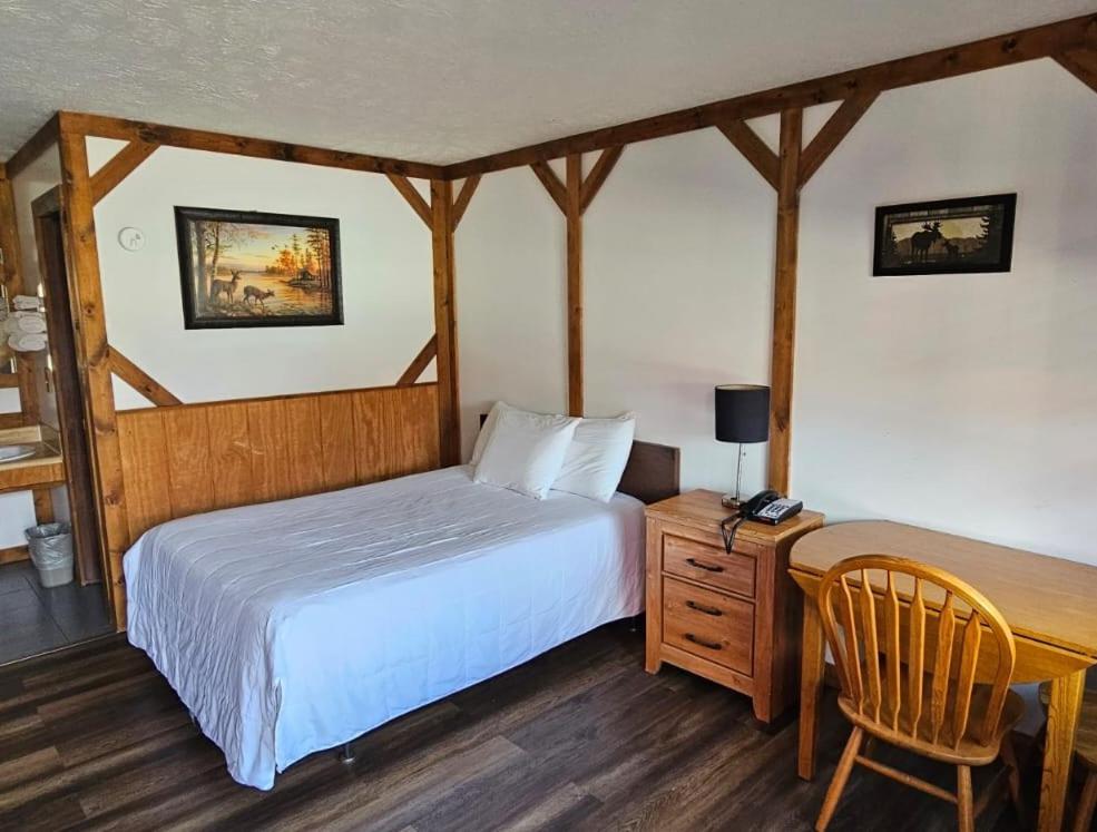 a bedroom with a bed and a desk with a chair at Beverly Hills Inn in Aberdeen