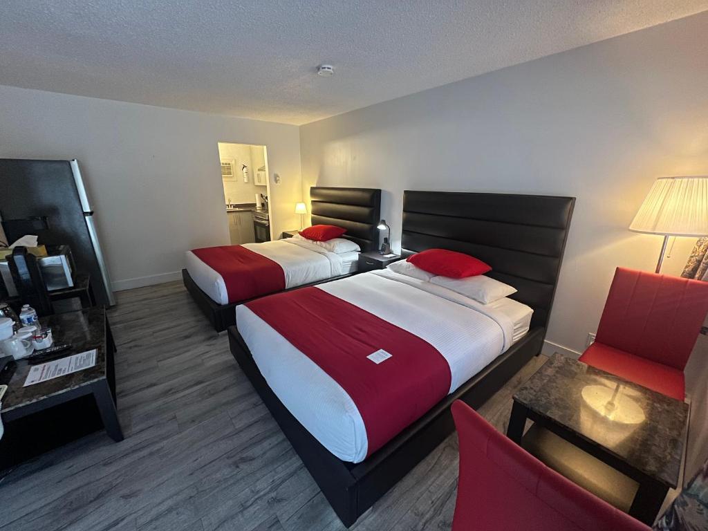 a hotel room with two beds with red pillows at Alpine Motel in Hope