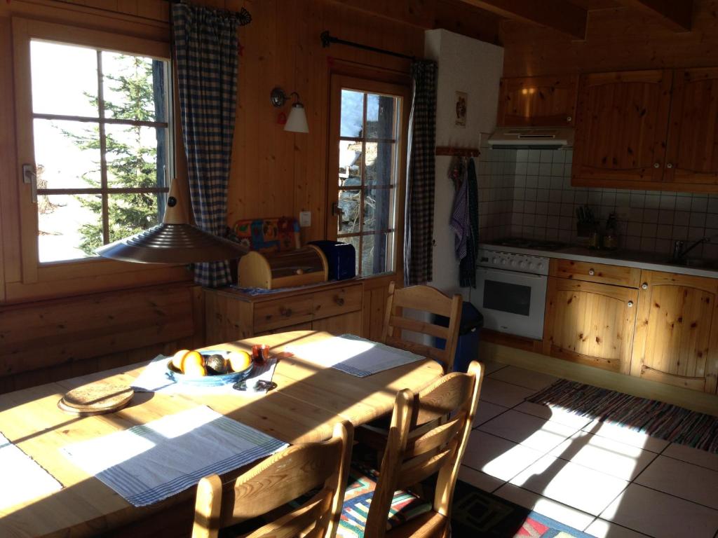 eine Küche mit einem Holztisch und Stühlen in der Unterkunft Chalet Annika in Grimentz