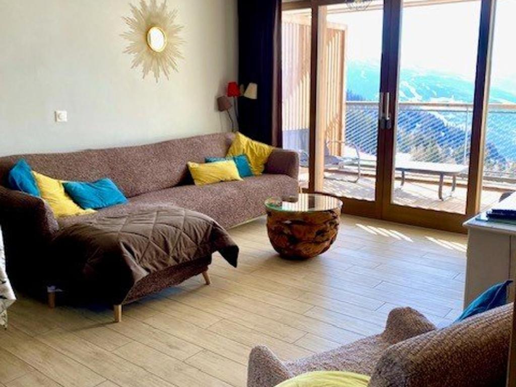 a living room with a couch and a large window at Luxueux 3 pièces aux Arcs 1600 avec piscine et spa, wifi, parking couvert, skis aux pieds - FR-1-461A-16 in Arc 1600