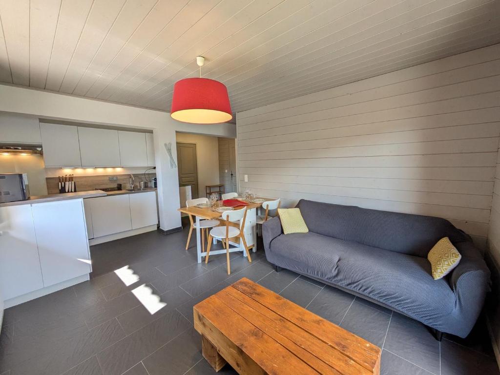 un salon avec un canapé bleu et une table dans l'établissement Appartement rénové aux Gets, proche centre et pistes, balcon sud - FR-1-623-160, aux Gets