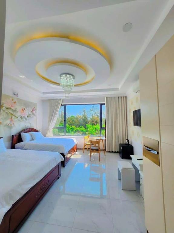 a hotel room with two beds and a chandelier at Apec Sunsea Homestay in Liên Trì (3)