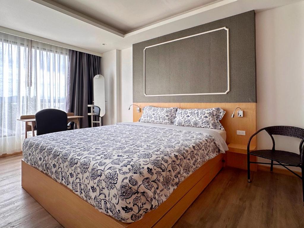 une chambre avec un lit et un tableau noir au mur dans l'établissement Aristo-2-805, à Ban Lum Fuang