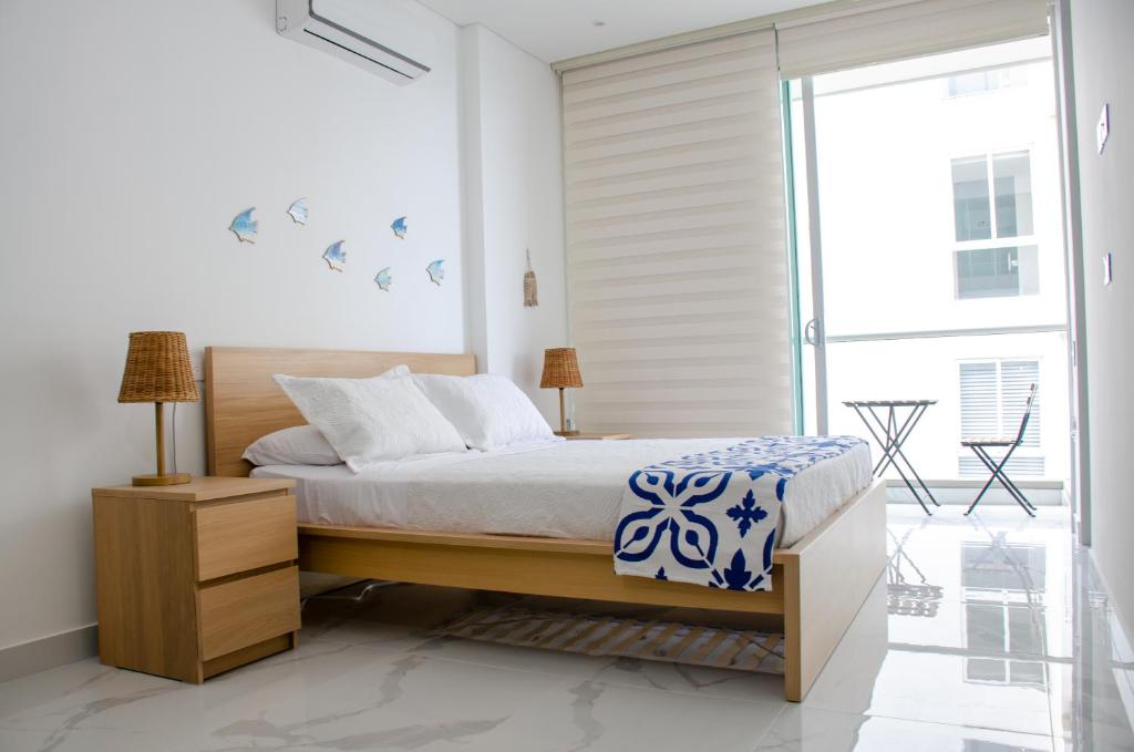 a bedroom with a bed and a sliding glass door at Nuevo Loft con vista al mar a pocos pasos de la playa in Santa Marta
