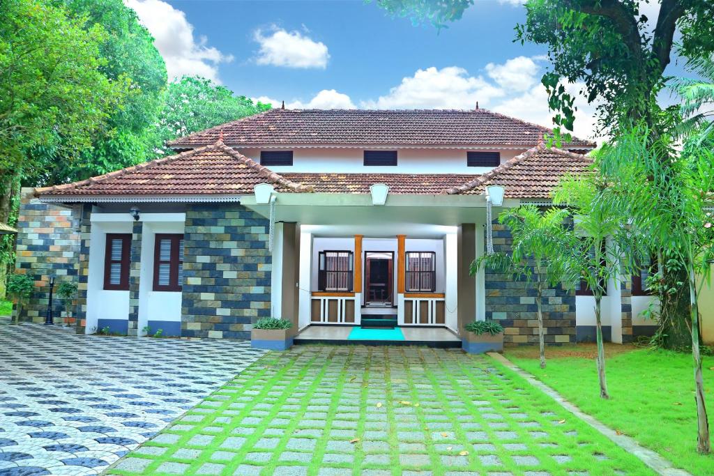 a house with a pathway in front of it at Pearl Beach Bungalow in Alleppey