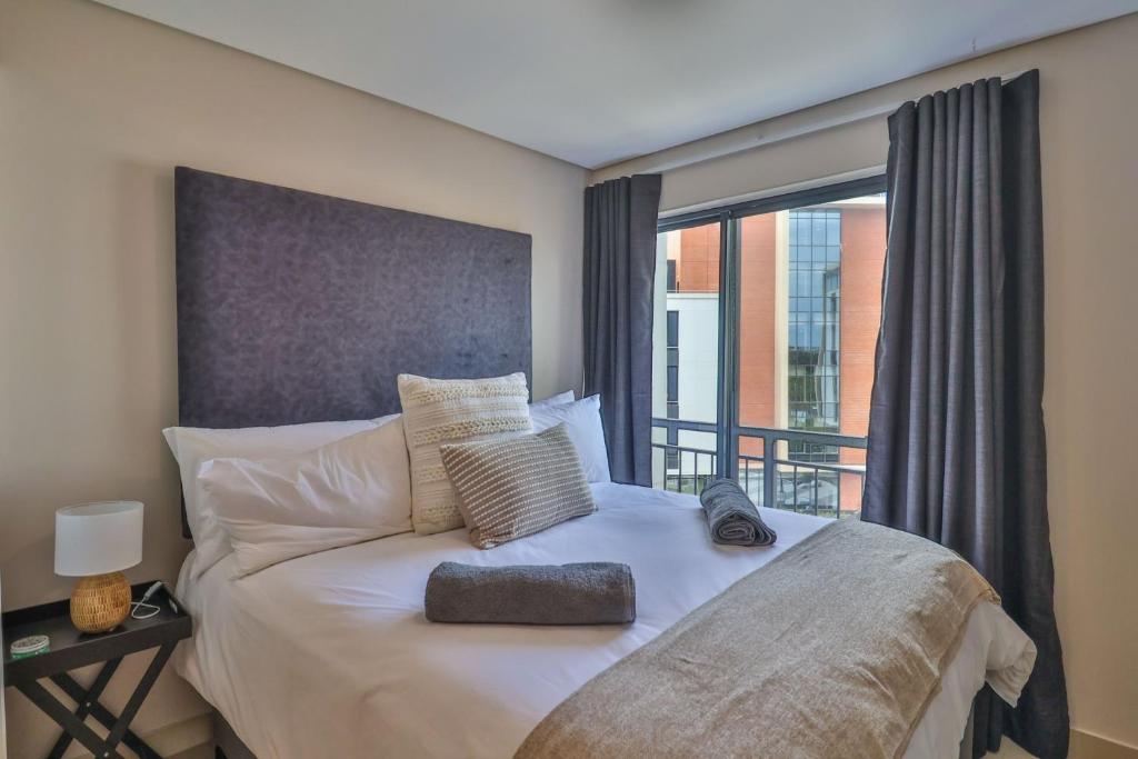 a bedroom with a bed with a large window at The Millennial Cosy stay in Durban