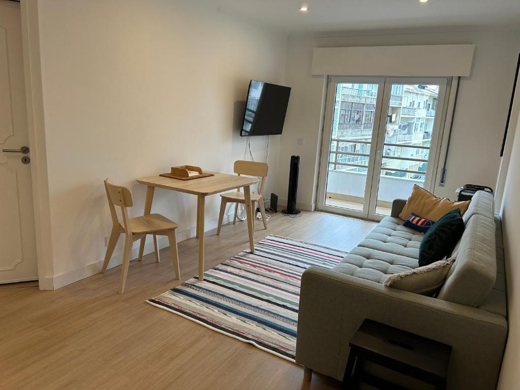 a living room with a couch and a table at A Minha Casinha in Almada
