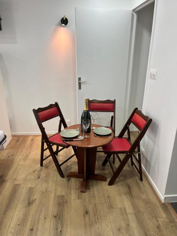 - une table en bois avec 2 chaises et une bouteille de vin dans l'établissement Studio idéalement placé, à Paris