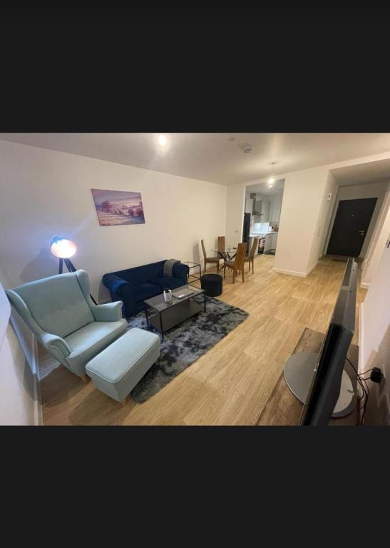 a living room with a blue couch and a tv at Peaceful home in Barking