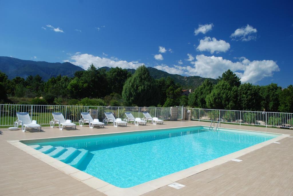 a swimming pool with lounge chairs at Residence Riviera in Porto-Vecchio