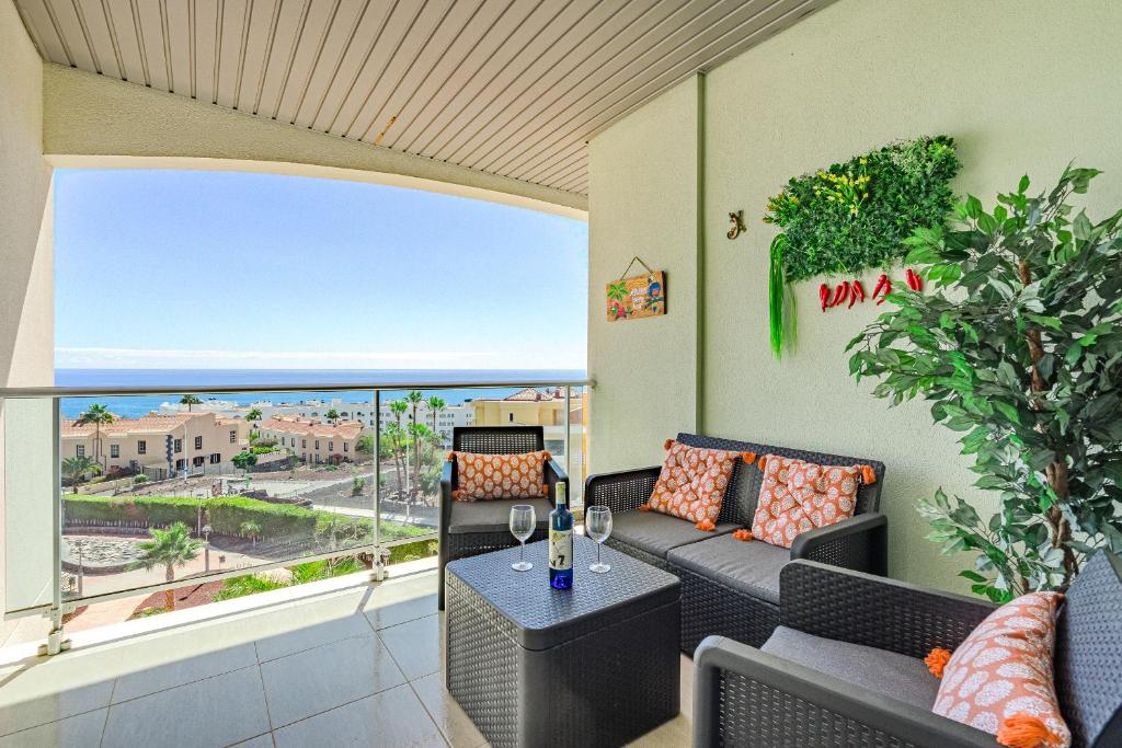 a living room with a couch and a table on a balcony at Trebol House, Edificio Cañadas, Golf del Sur in San Miguel de Abona