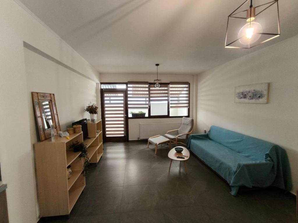 a living room with a blue couch and a chair at Coralia's House in Nea Moudania