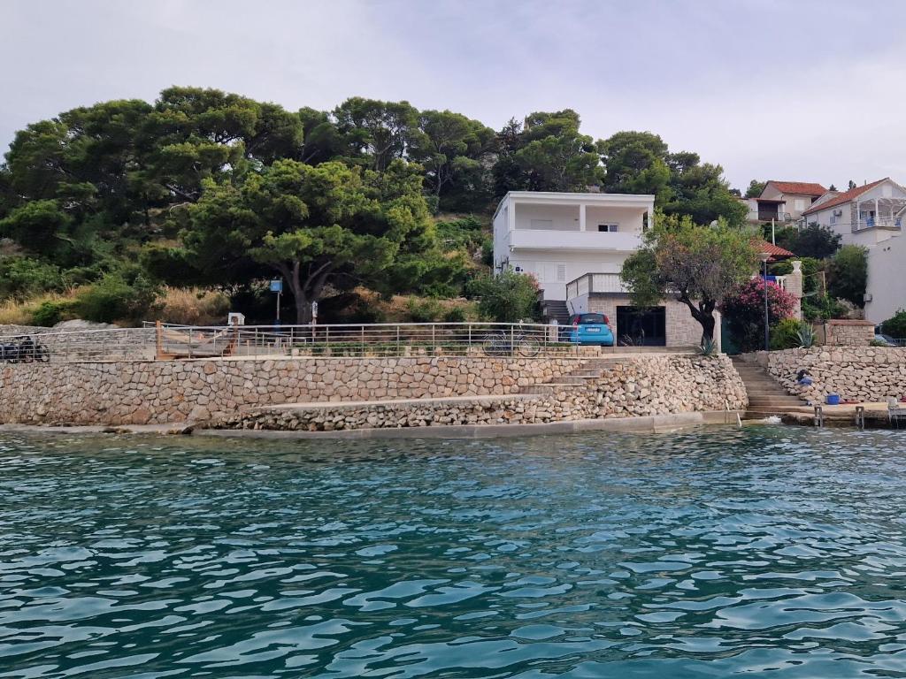 a house on the shore of a body of water at Apartment Vjera in Tisno