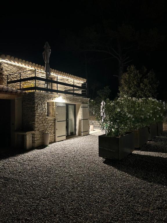 - un bâtiment en pierre avec un garage la nuit dans l'établissement Charmante maison Provençale avec grand jardin, à LʼIsle-sur-la-Sorgue