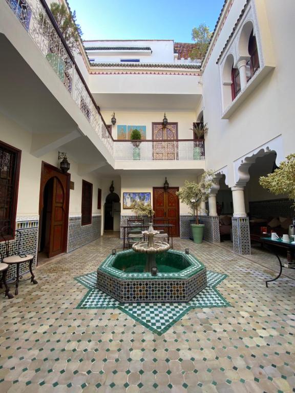 um pátio com uma fonte no meio de um edifício em Riad Dar Teranga Hotel & Spa em Marraquexe