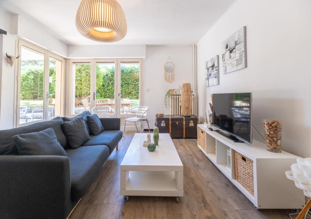 un salon avec un canapé bleu et une télévision dans l'établissement L'évasion de Portissol, à Sanary-sur-Mer