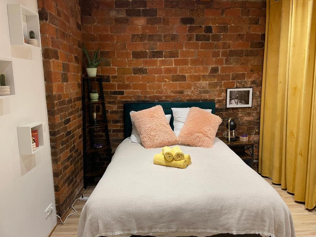 une chambre avec un lit avec un mur de briques dans l'établissement Superbe Studio Montmartre, rue des Abbesses, à Paris