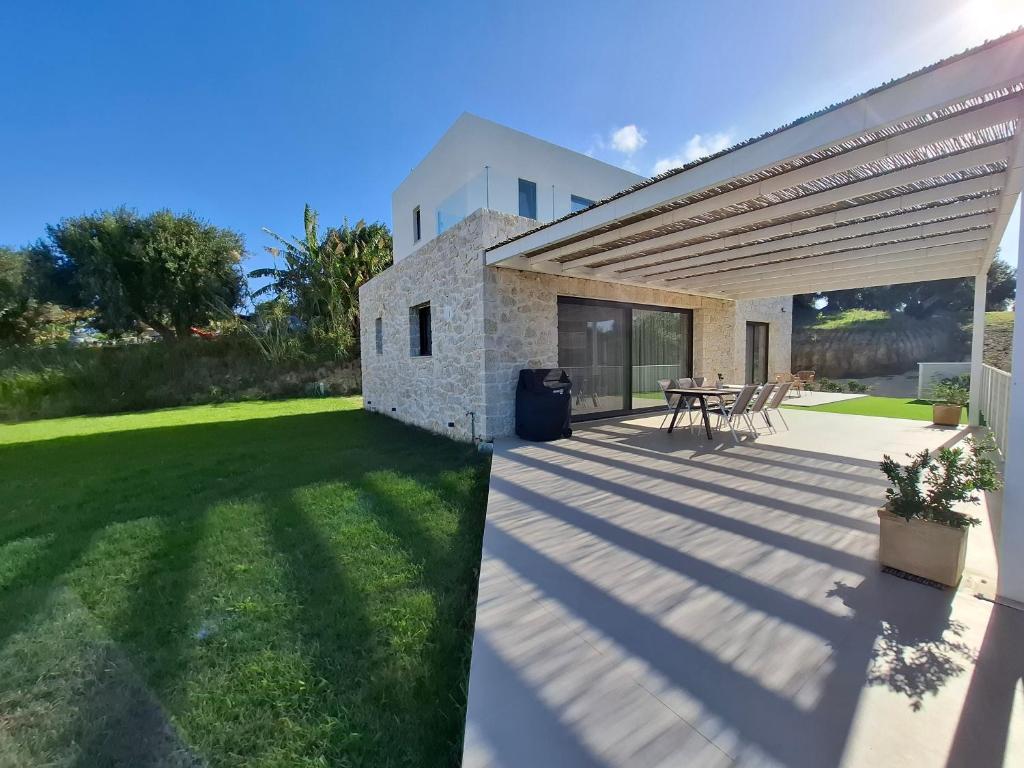 a patio with a table in a yard at Arillas Villas dinos in Arillas