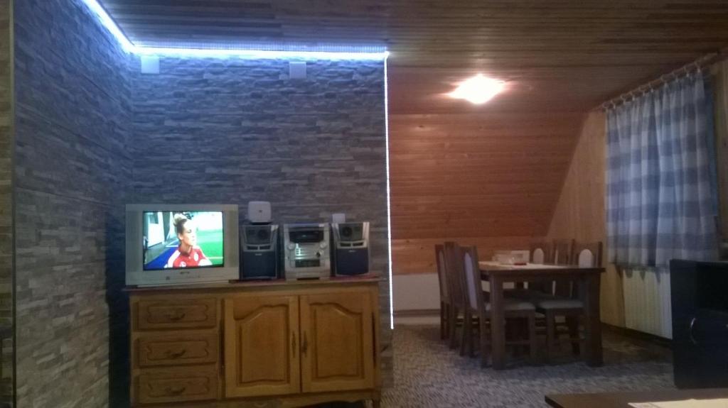 sala de estar con TV en un tocador con mesa en Apartments Dora en Jahorina