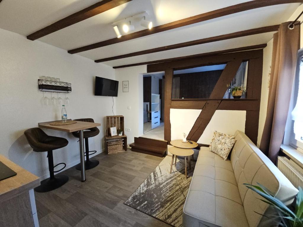 ein Wohnzimmer mit einer Couch und einem Tisch in der Unterkunft Gemütliche Ferienwohnung im Westerwald - "Ferienwohnung Braun" in Weitefeld