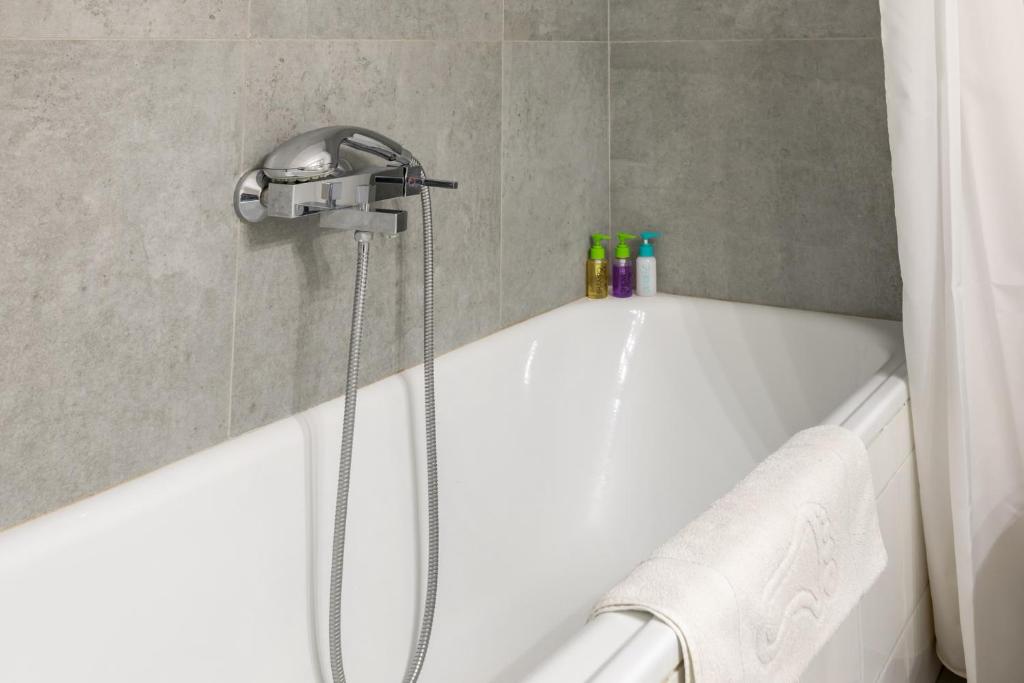 W łazience znajduje się wanna z głowicą prysznicową. w obiekcie Chania dream apartment w Chanii