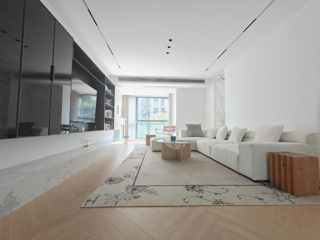 a living room with a white couch and a table at Eastern Hub - Bund Branch Designer Open Kitchen Super Large Sofa Deluxe Three Room in Shanghai