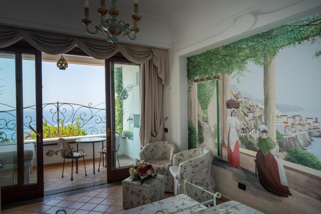 a living room with a wall mural of a balcony at Albergo La Conca Azzurra in Conca dei Marini