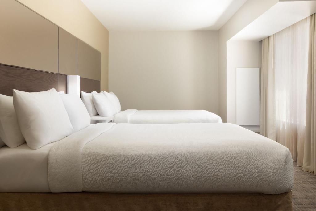 ein weißes Schlafzimmer mit 2 Betten und einem Fenster in der Unterkunft Residence Inn by Marriott Las Vegas Airport in Las Vegas