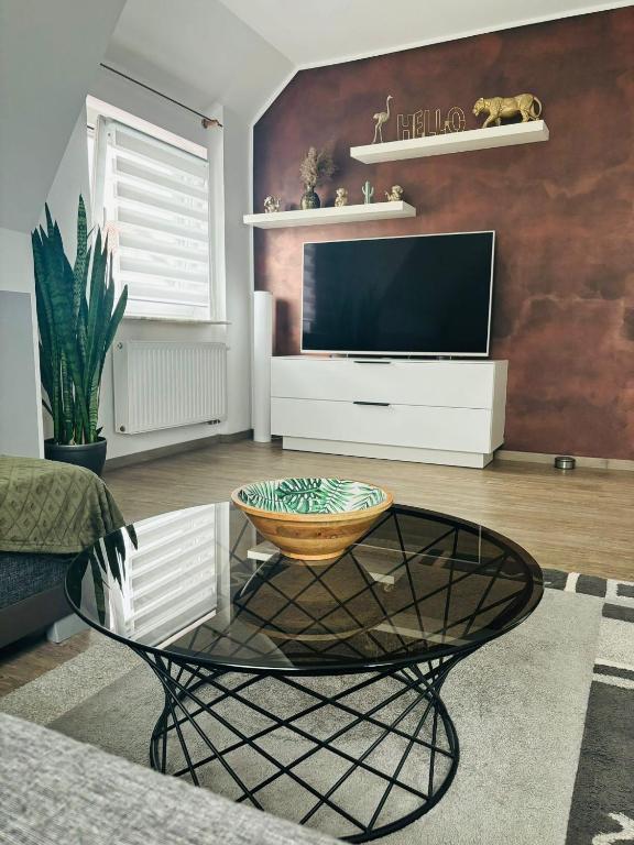 a living room with a television and a table at Casa Paletta -Modern -Terrasse -Parkplatz -Küche in Sigmaringen