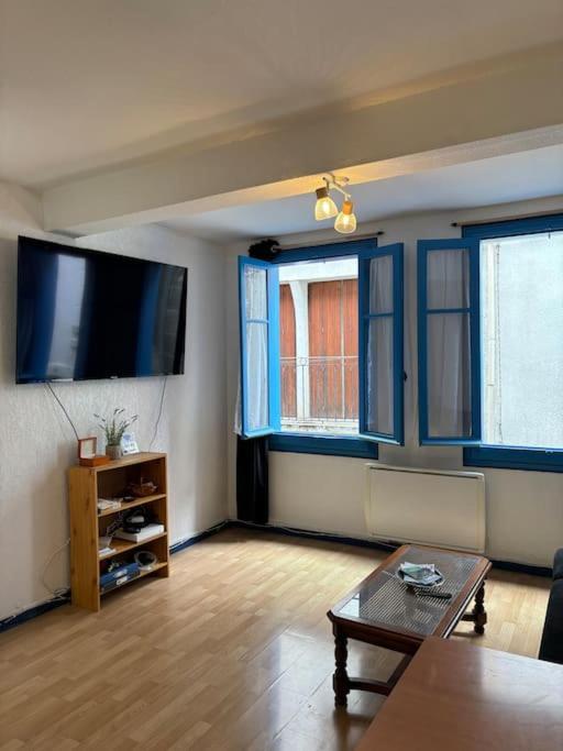 un salon avec une télévision à écran plat et une table dans l'établissement Central apartment in Quillan, à Quillan