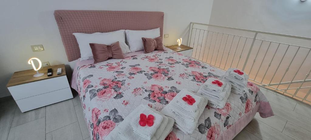 ein Schlafzimmer mit einem großen Bett mit rosa Blumen drauf in der Unterkunft DV House Via toledo QuartieriSpagnoli in Neapel