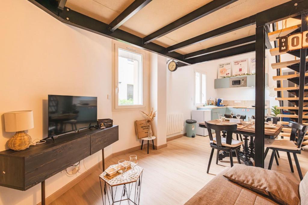 un salon avec une télévision et une salle à manger dans l'établissement Loft type industriel, à Reims