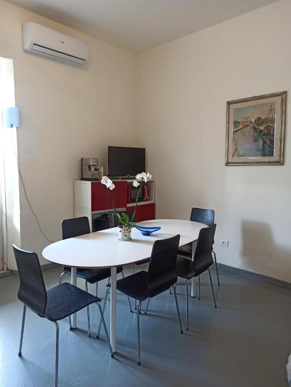 a room with a table and chairs and a tv at Appartamento Vale in Viareggio