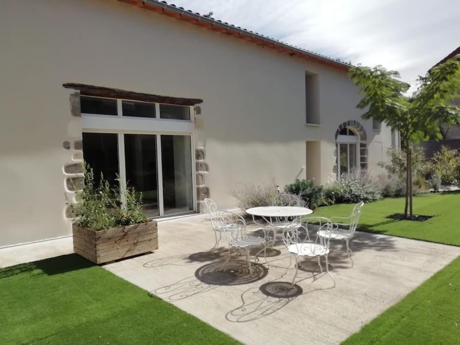 un patio avec une table et des chaises dans une cour dans l'établissement Résidence familiale au calme adaptée PMR, à Meilhaud