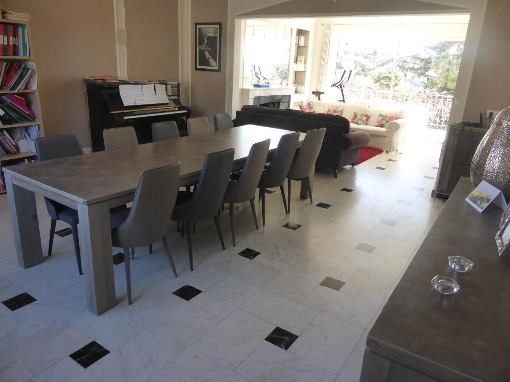 - un salon avec une table, des chaises et un piano dans l'établissement Très grande maison lumineuse, à Boulogne-sur-Mer