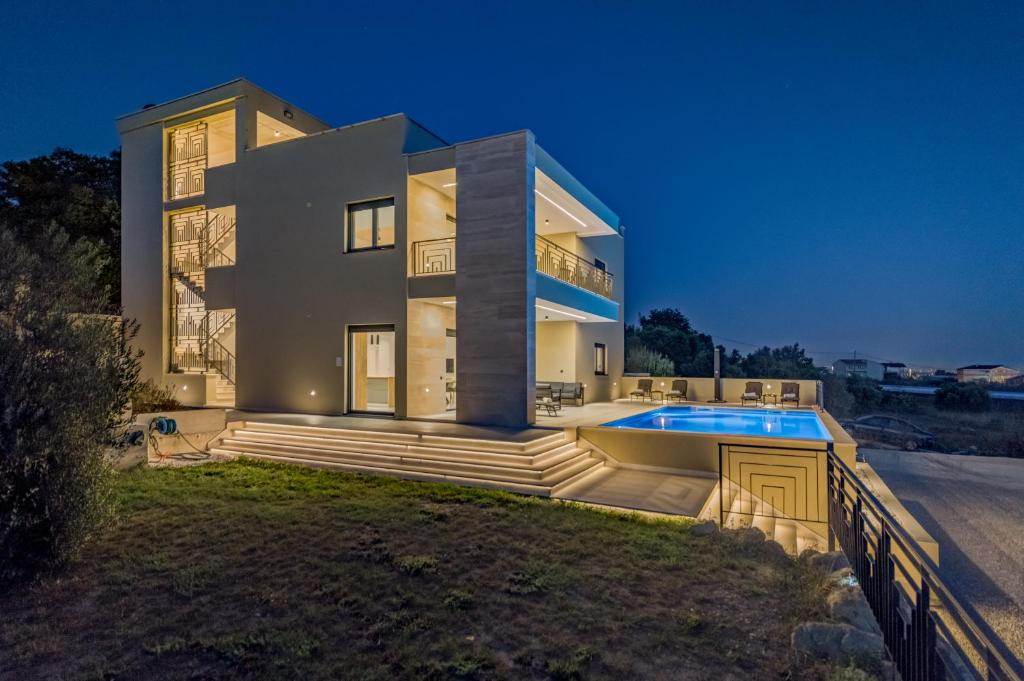 ein großes Haus mit einem davorliegenden Swimmingpool in der Unterkunft Luxury Villa Providenza in Kaštela